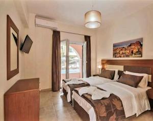 een slaapkamer met 2 bedden en een groot raam bij BELLA De LUX APTS in Ýpsos