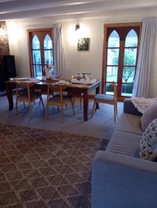 uma sala de estar com uma mesa e um sofá em Kingsdown Manor B&B Timaru em Timaru