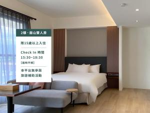 花蓮市にあるMoon Nine Villaのベッドと椅子付きのホテルルーム