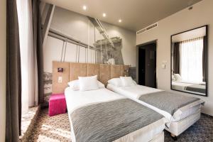 1 dormitorio con 1 cama grande y espejo grande en Carat Boutique Hotel, en Budapest