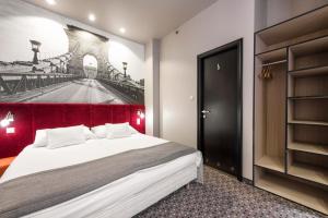 a bedroom with a bed and a painting of a bridge at Carat Boutique Hotel in Budapest