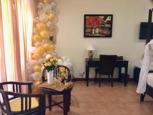 een kamer met een tafel met ballonnen en een bureau bij Cham Villas Resort in Mũi Né