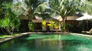 una piscina en un complejo con palmeras en Cham Villas Resort, en Mui Ne