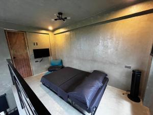 a bedroom with a bed and a tv in it at Patar Palms in Bolinao
