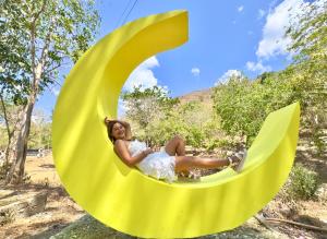 a woman sitting on a yellow crescent swing at Mount Avangan Eco Adventure Park in Coron
