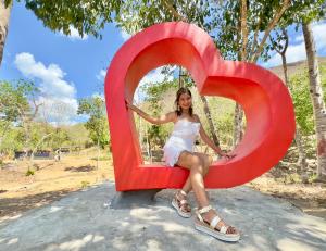 a woman sitting inside of a large heart sculpture at Mount Avangan Eco Adventure Park in Coron