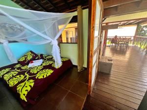 Teahupootahiti-bungalow at Teahupoo: beachfront with pountoon and mini pool的一间卧室配有一张带蚊帐的床