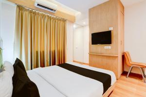 Habitación de hotel con cama y TV en OYO Hotel Silver Cloud en Thane