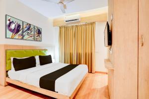 ein Schlafzimmer mit einem großen Bett und einem TV in der Unterkunft OYO Hotel Silver Cloud in Thane