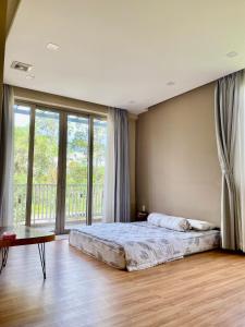 a bedroom with a bed and a large window at Green villa in Bien Hoa