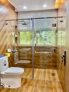 a bathroom with a toilet and a glass shower at Green villa in Bien Hoa