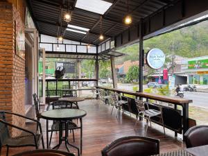 a restaurant with tables and chairs in a building at ALPHA Hostel Cafe&Bar in Ban Khlong Yai