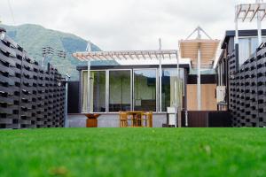 a house with a green lawn in front of it at グランステイ湯布院 GranStay YUFUIN in Yufu