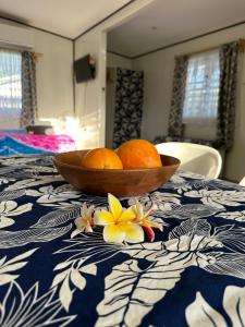 Amuri的住宿－Rangiriri Vacay，两个橙子在桌上放着鲜花的碗里