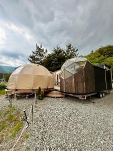 富士河口湖町にあるFuji Dome Glampingのテント数台、トレーラー1台