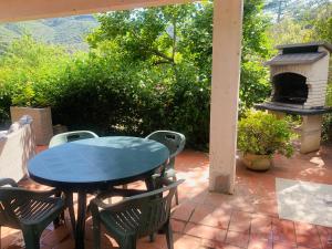 a patio with a table and chairs and an outdoor oven at Case dei limoni sul mare in Capoliveri