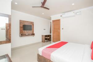 sypialnia z łóżkiem i telewizorem na ścianie w obiekcie Super OYO High Street MG Road w mieście Bengaluru