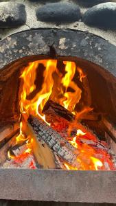 a fire in a brick oven with flames at Cottage by the river Valea Draganului in Poeni