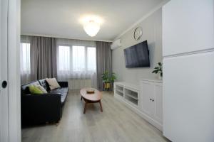 ein Wohnzimmer mit Sofa und Tisch in der Unterkunft Жк Арбат двух комнатная in Almaty
