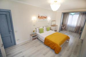 ein Schlafzimmer mit einem Bett mit einer gelben Decke in der Unterkunft Жк Арбат двух комнатная in Almaty