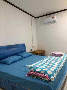 una camera da letto con un letto blu con cuscini blu di Meenoy hotel Vientiane Laos 旅館 a Ban Doung
