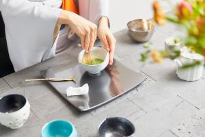 a woman is mixing a bowl on a table at Park Hotel Tokyo in Tokyo