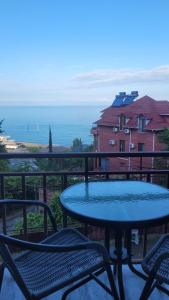 a table and chairs on a balcony with the ocean at PharphalInn in Batumi
