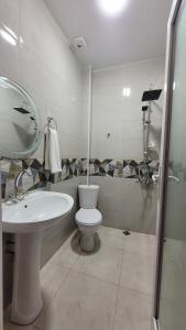 a bathroom with a sink and a toilet and a mirror at PharphalInn in Batumi