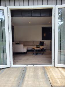 an open door to a living room with a couch at Nieuwe vakantie-Chalet "Bie mammie en pette" in Bocholt