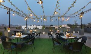 un patio con mesas y sillas en un techo con luces en Treebo Trend Dream Palace, en Jaipur