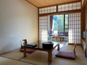 salon ze stołem i pokój z oknem w obiekcie Wafu Ryokan Misato w mieście Minamioguni