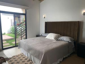 a bedroom with a large bed with a large window at Casa de ensueño, jacuzzi-fogata in La Cuadrilla