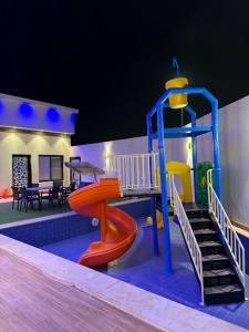 une aire de jeux pour enfants avec toboggan et structure de jeux dans l'établissement لاڤانا, à Unayzah