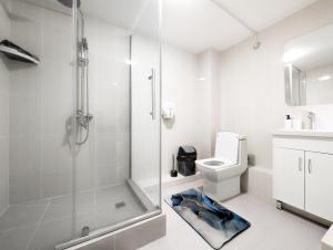 a white bathroom with a shower and a toilet at Wanderlust hostel Riverside in Almaty +87 photos