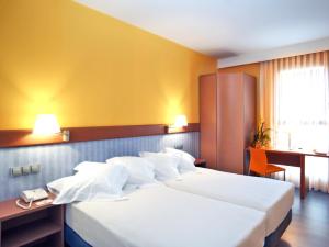 a hotel room with two beds and a yellow wall at Hotel Murrieta in Logroño