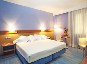 a hotel room with a large bed with white sheets at Hotel Murrieta in Logroño