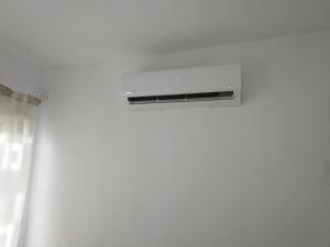 a air conditioner on a white wall in a room at casa tranquila in Naranjo