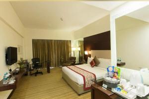 um quarto de hotel com uma cama e uma secretária em Hotel Airport inn plaza near delhi airport Aerocity em Nova Deli