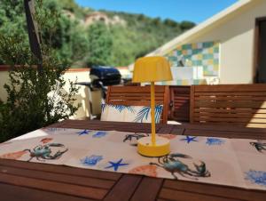 un tavolo con una lampada sopra un tavolo di Appartamento La Terrazza - Località Cala Gavetta a La Maddalena