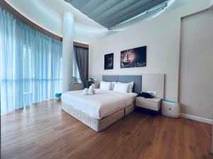 um quarto com uma grande cama branca e pisos em madeira em AP Concept Hotel em Petaling Jaya