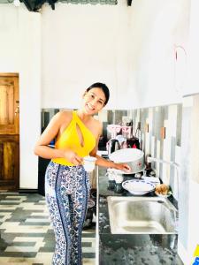 a woman standing in a kitchen preparing food at R & D Resort in Polonnaruwa