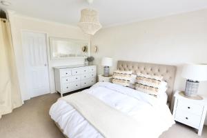 a white bedroom with a white bed and a white dresser at Harbour Haven*Sea View*WIFI*Wine*Walk to the Beach in Robe