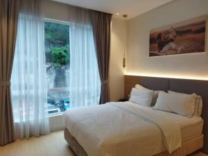 um quarto com uma cama e uma grande janela em AP Concept Hotel em Petaling Jaya