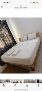 uma cama com lençóis brancos e almofadas brancas em Giana’s stays with pool em Mombaça