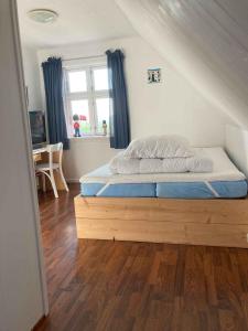 a bed with a wooden frame in a bedroom at Holiday Home In Poulsker in Neksø