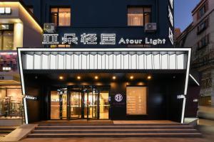 Atour Light Hotel Shenyang Tiexi Plaza Wanxianghui في شنيانغ: واجهة متجر مع علامة تنص على ضوء السهم