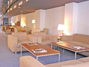 a waiting room with couches and tables and chairs at Hotel Murrieta in Logroño