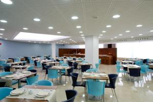 a dining room with tables and blue chairs at Hotel Murrieta in Logroño