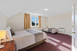 a hotel room with a bed and a window at Riverfront Motel & Restaurant in Hobart
