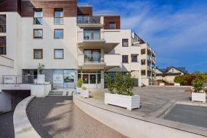 un immeuble d'appartements avec une piscine en face dans l'établissement MS Apart Władysławowo, à Władysławowo